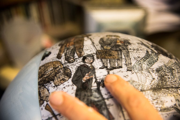 Globus mit historischer Weltkartendarstellung und Figuren