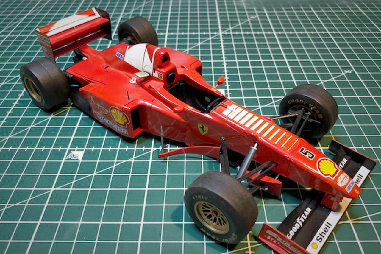 Rotes Formel-1-Modellauto auf einer Schneidematte