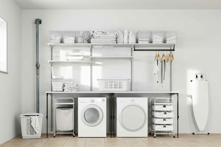 Heller Waschraum mit Waschmaschine, Trockner, Regalen und Wäschekörben