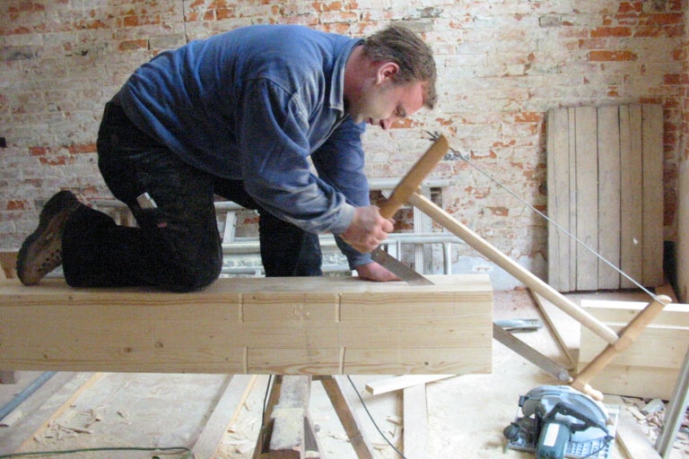 Handwerker sägt Holz mit einer Schrotsäge