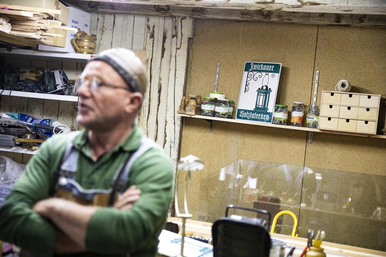 Werkstatt mit Werkzeugen, Aufbewahrungsgläsern und Holzprodukten auf Regalen.