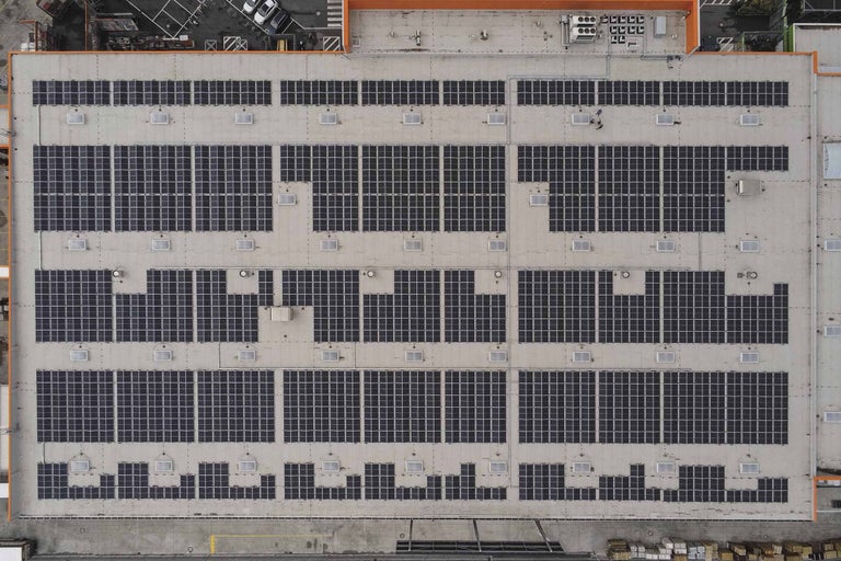 Luftaufnahme eines Gebäudedachs mit Solaranlagen