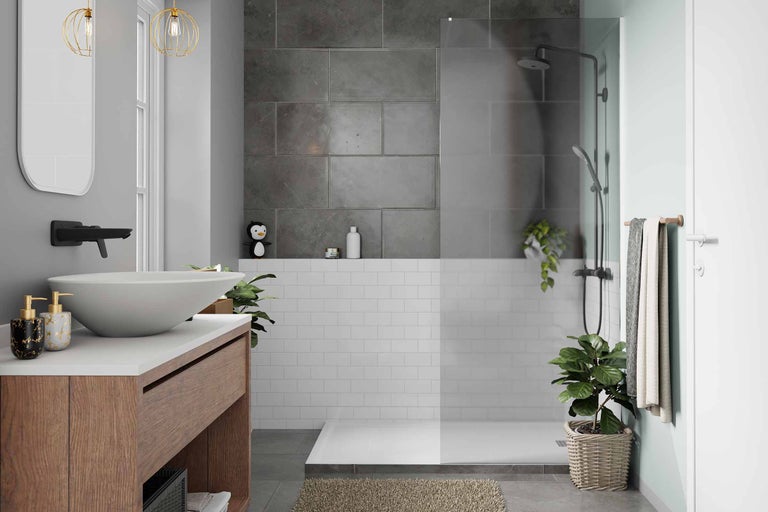 Badezimmer mit Waschtisch, Spiegel, Dusche und grauen sowie weißen Fliesen