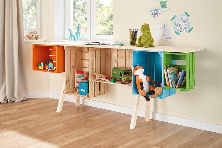 Kinderschreibtisch aus Holzkisten mit Spielsachen und Dekoration