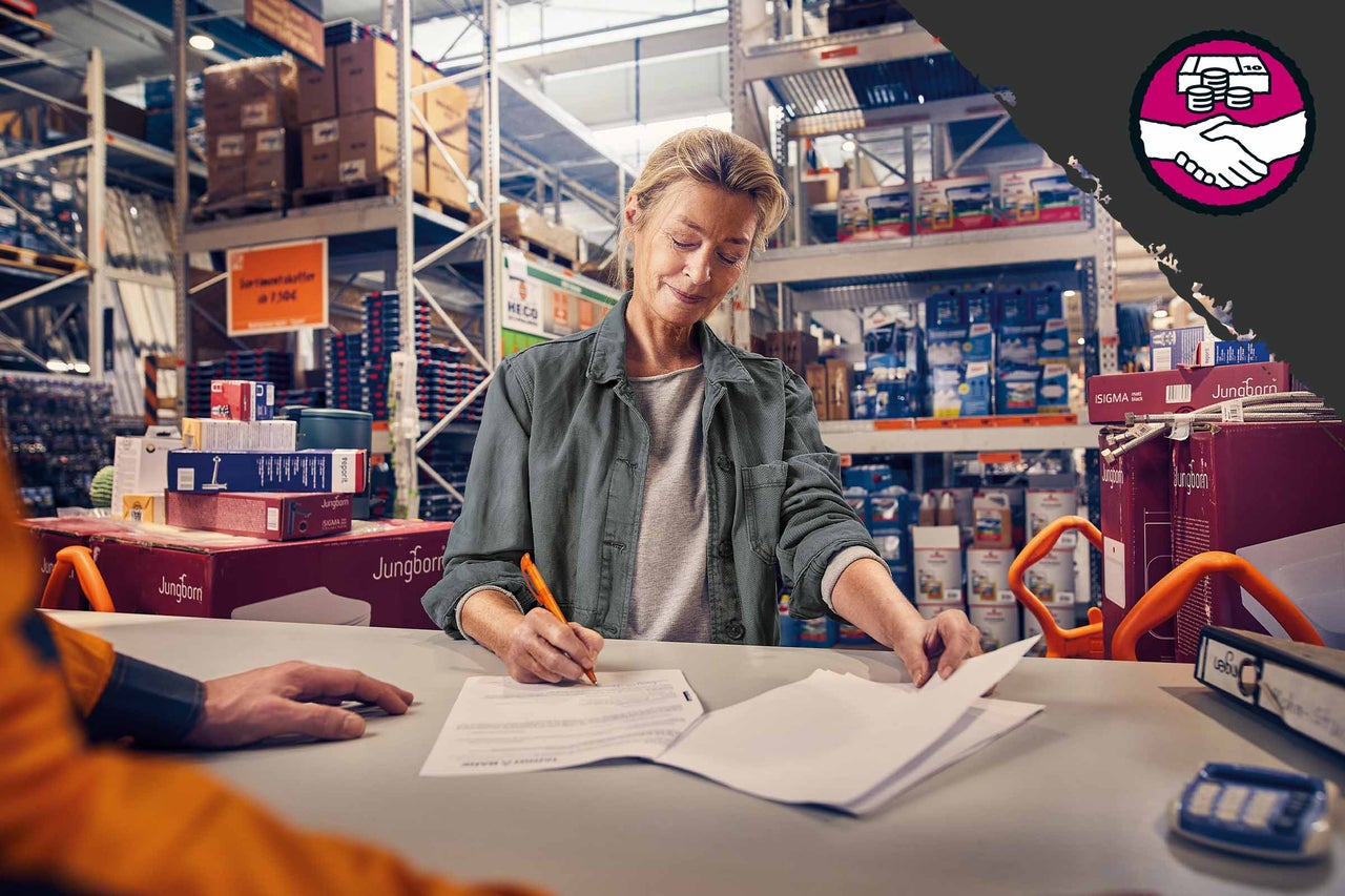 Eine Kundin unterschreibt ein Dokument bei Hornbach. Symbol für Preisgarantie.