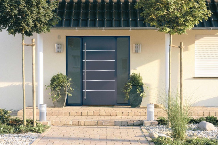 Eingangsbereich eines Hauses mit Haustür, Beleuchtung und Pflanzen