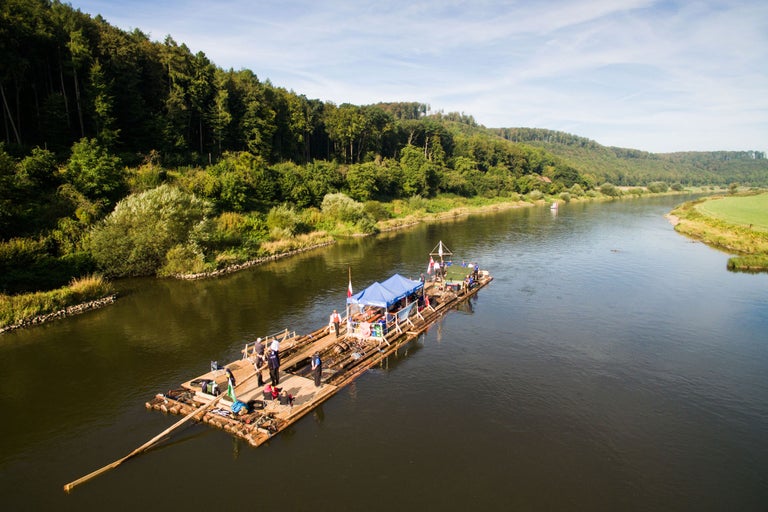 Fluss mit einem Holzfloß mit Personen