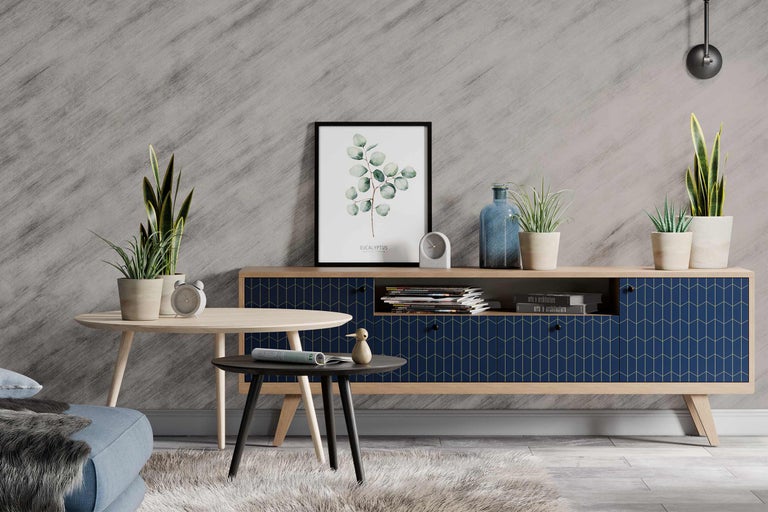 Wohnzimmer mit Kommode, Tischen und Zimmerpflanzen