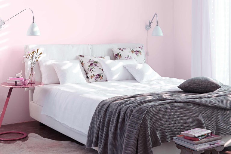 Einladendes Schlafzimmer mit Bett, Kissen, Decke und Nachttisch