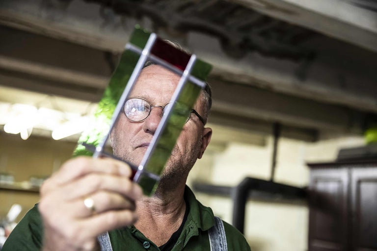 Mann betrachtet Glasstück für Glasarbeiten