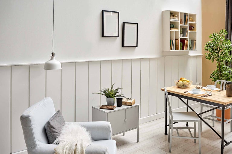 Helles Wohnzimmer mit Sessel, Tisch, Dekoration und Wandregal