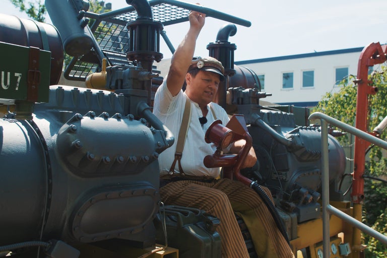 Eine Person bedient eine historische Maschine.