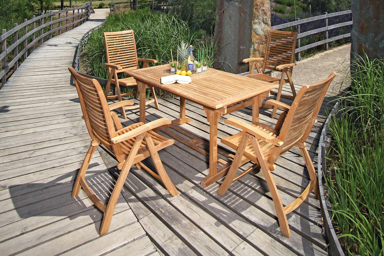 Gartenszene mit Teakholztisch und vier Stühlen auf Holzterrasse
