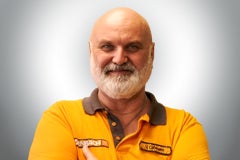 Porträt eines freundlichen Mannes mit Bart und gelbem Poloshirt