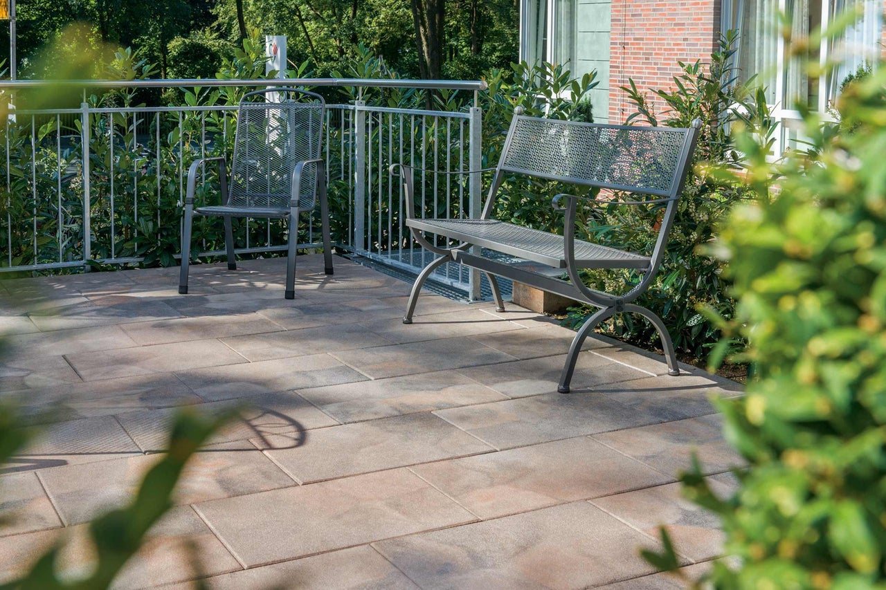 Terrasse mit Steinplatten, Gartenbank und Stuhl