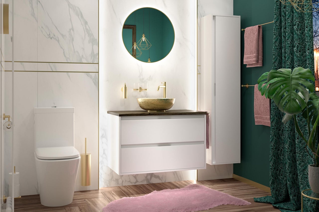 Modernes Badezimmer mit weißem Waschtischunterschrank, goldener Waschschale, beleuchtetem Rundspiegel, weißer Toilette und Wänden in Marmoroptik.