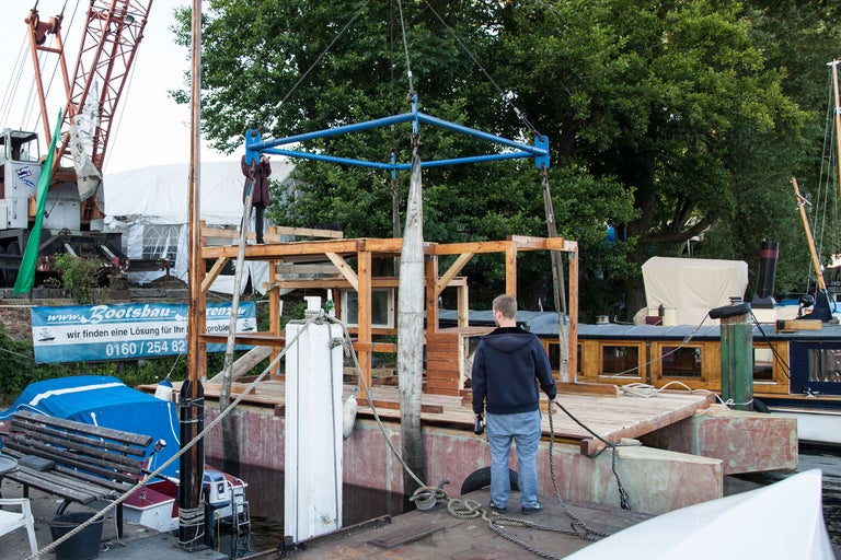 Szene einer Kran hebt eine Betonstruktur in einer Bootswerft.