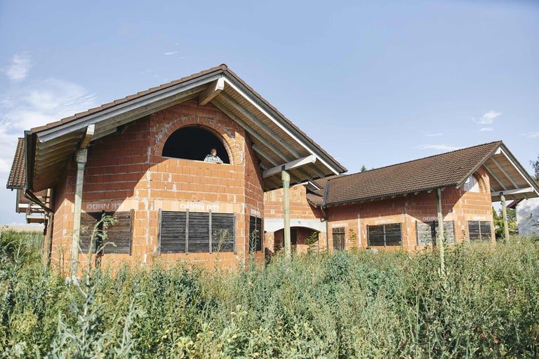 Unfertiges Haus mit Ziegelmauerwerk unter blauem Himmel