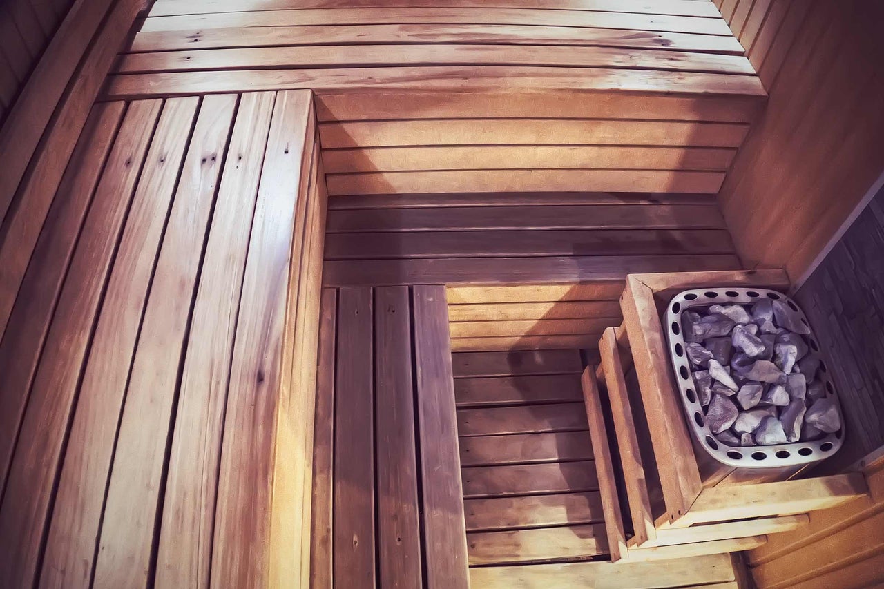 Innenansicht einer Sauna mit Holzverkleidung und Saunasteinen