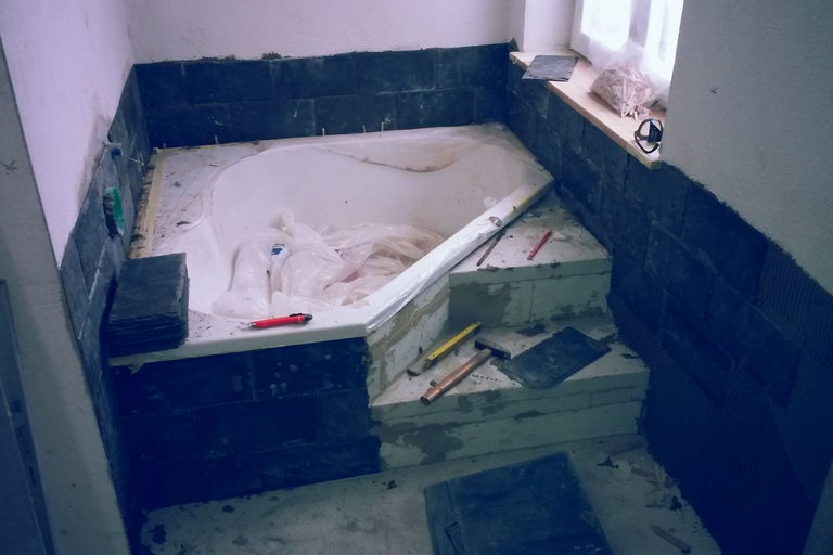 Badezimmerrenovierung mit Fliesen, Badewanne und Werkzeugen