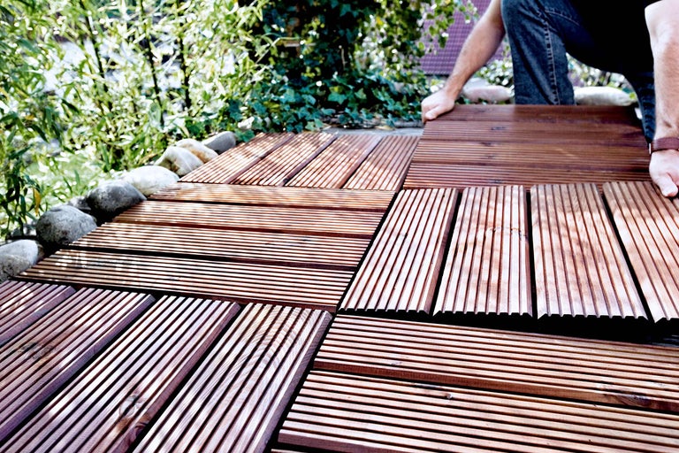 Verlegung von braunen Terrassenfliesen im Garten