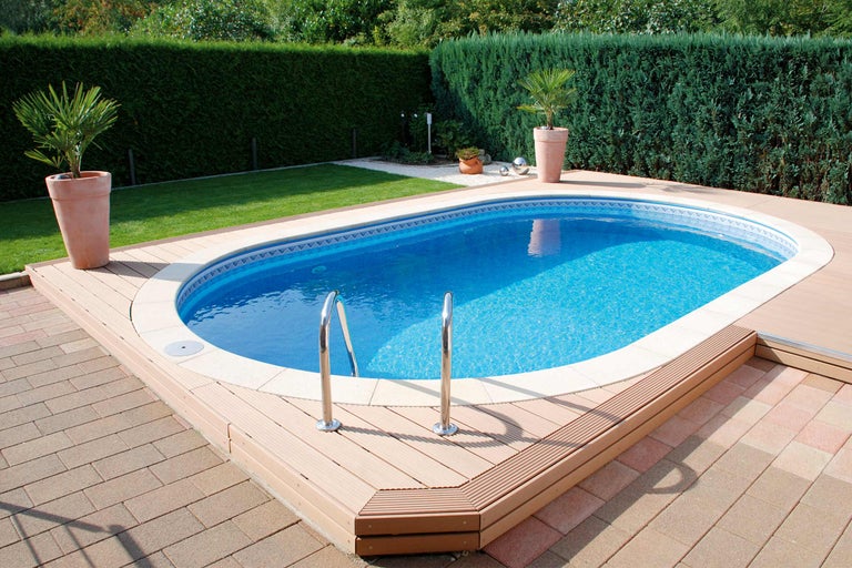 Pool mit Holzterrasse und Leiter in einem Garten.