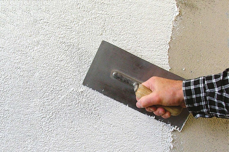 Außenputz wird mit einer Glättkelle aufgetragen