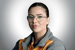 Porträt einer Frau mit Brille und Arbeitskleidung