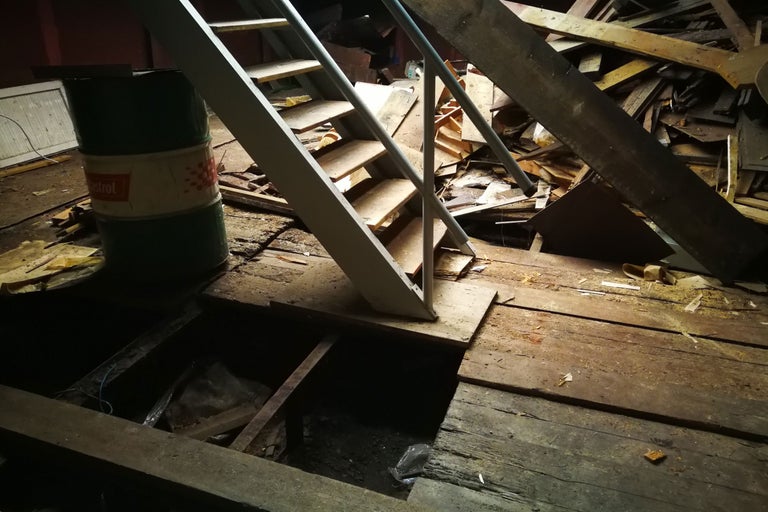 Dachboden mit Treppe, Holzresten und Ölfass
