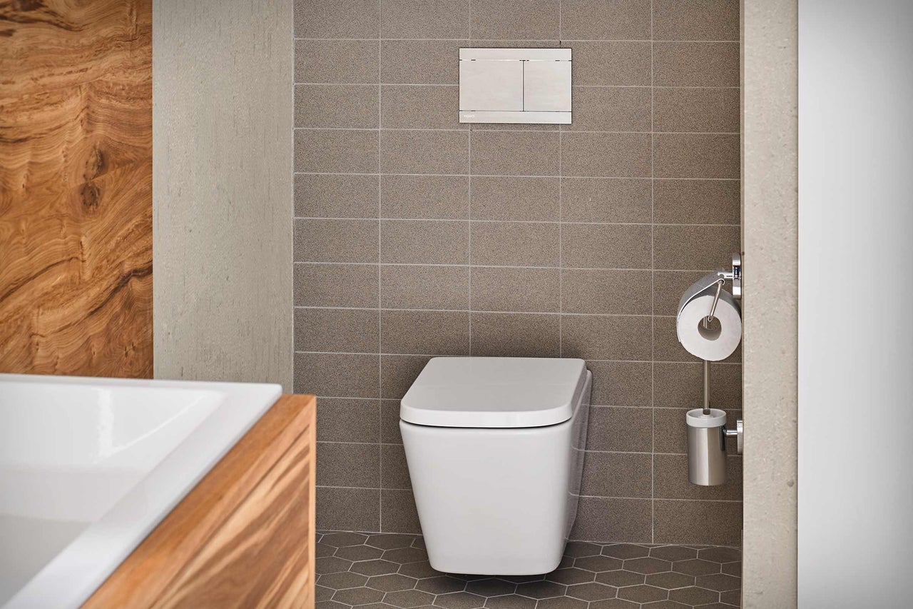 Modernes Badezimmer mit wandhängendem WC, Betätigungsplatte und Toilettenpapierhalter