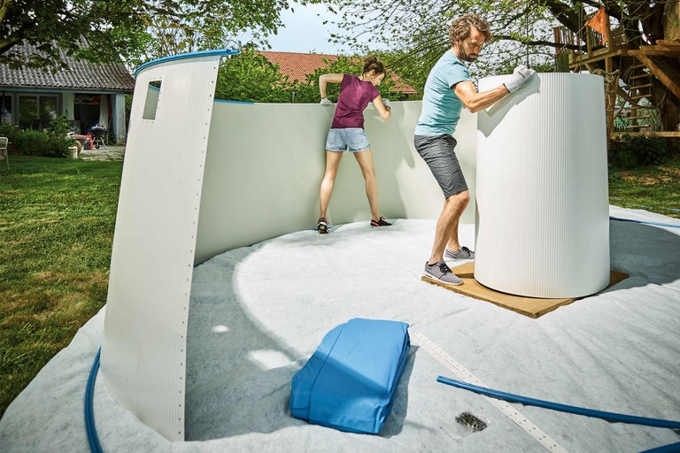 Zwei Personen montieren ein Gartenpool im Freien.
