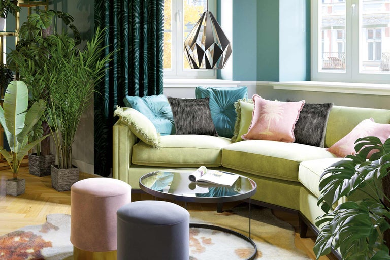 Wohnzimmer mit Sofa, Kissen, Beistelltischen, Teppich, Zimmerpflanzen und Pendelleuchte