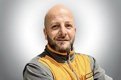 Porträt eines lächelnden Mannes in Arbeitskleidung