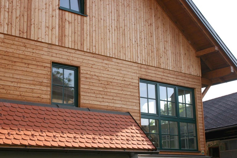 Fassade eines Hauses mit Holzverkleidung und Fenstern