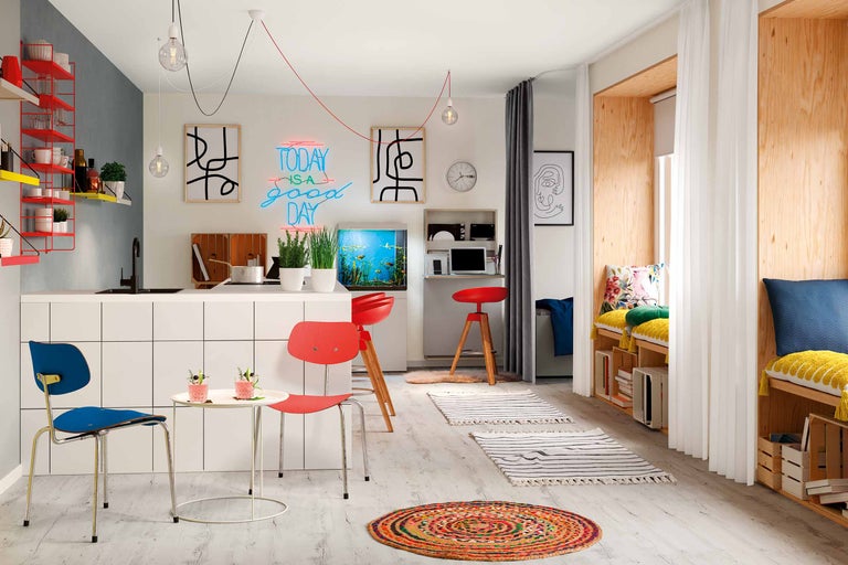 Heller Wohnraum mit Küche, Sitzgelegenheiten und Dekoration