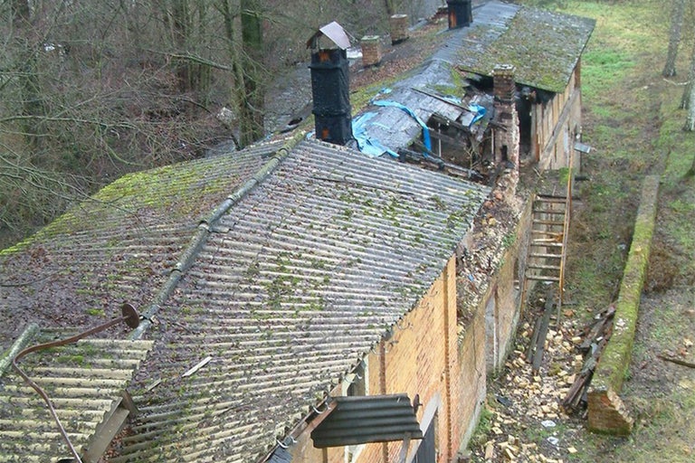 Ansicht eines verlassenen Gebäudes mit beschädigtem Dach und Ziegelmauerwerk