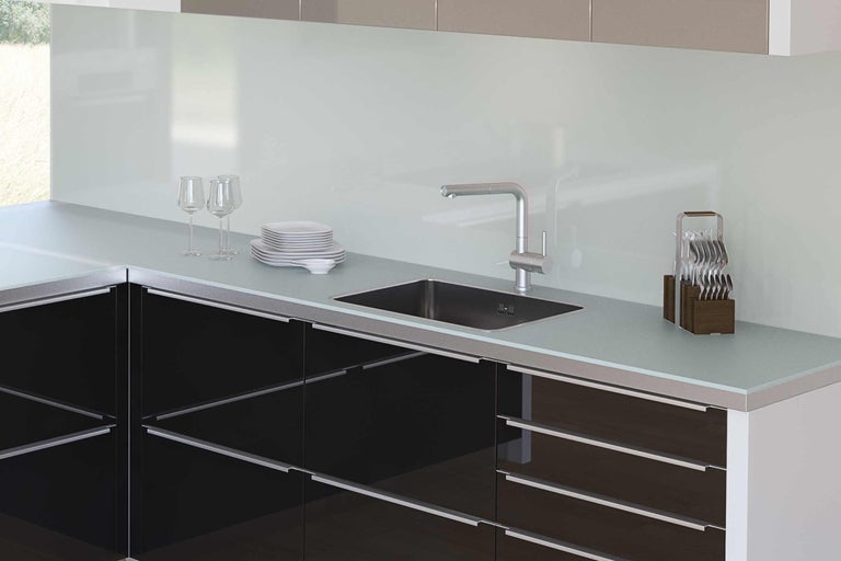 Moderne Küche mit Spüle, Armatur und Küchenutensilien auf der Arbeitsfläche.