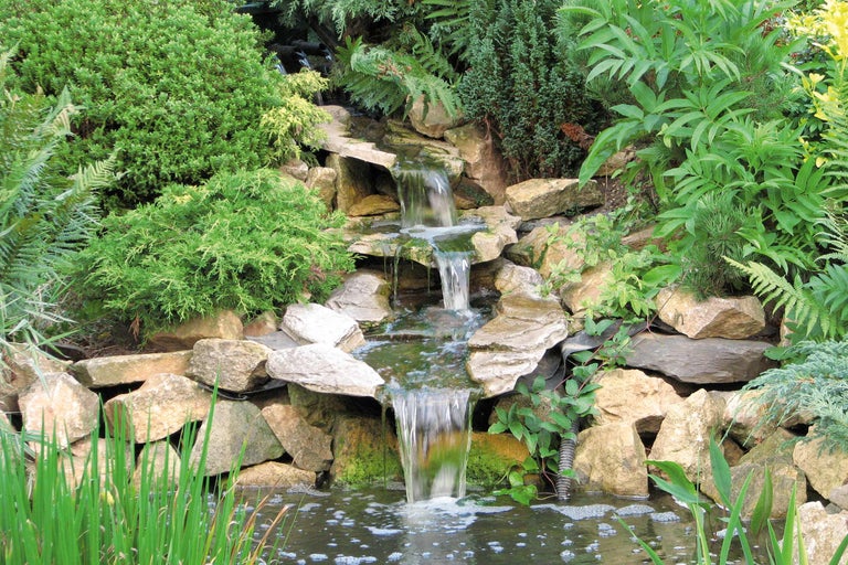 Gartenteich mit Wasserfall und Felsen