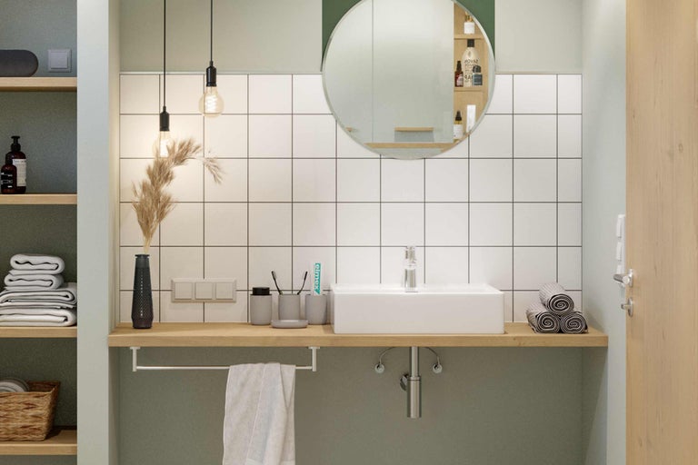 Badezimmer mit Waschbecken, Spiegel und Handtüchern.