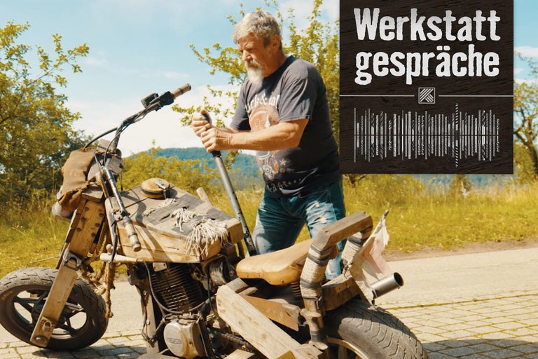 Mann steht neben einem Motorrad mit Holzverkleidung und dem Text Werkstattgespräche.