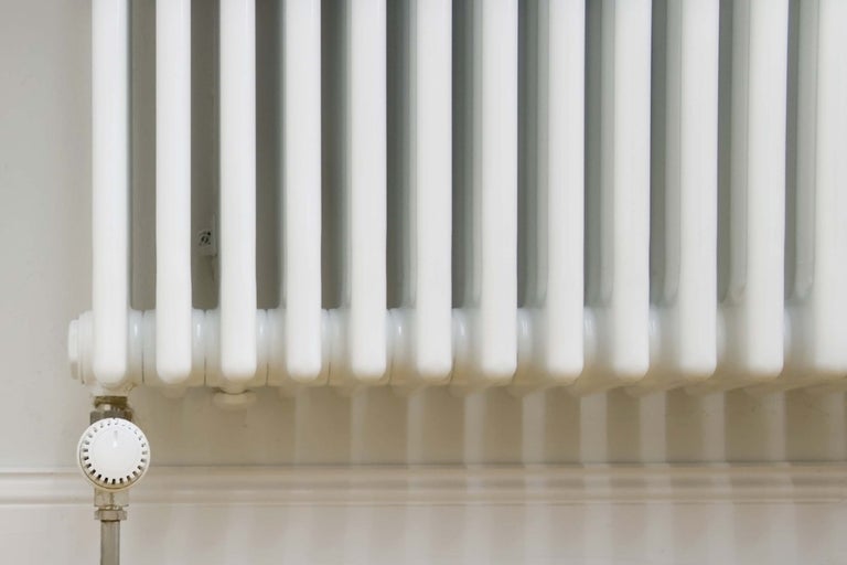 Weißer Rippenheizkörper mit Thermostatventil