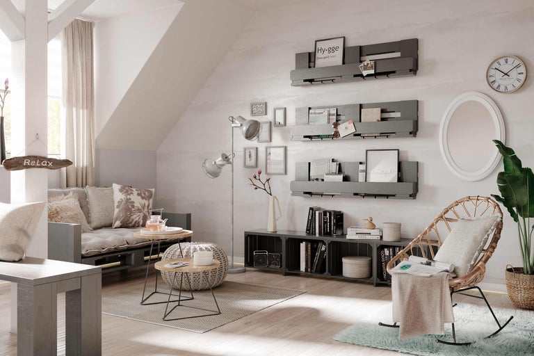 Gemütliches Wohnzimmer mit Sofa, Bücherregalen, Sessel und Beistelltischen