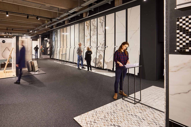 Ausstellungsraum mit einer Auswahl an Fliesen und Kunden bei der Beratung.