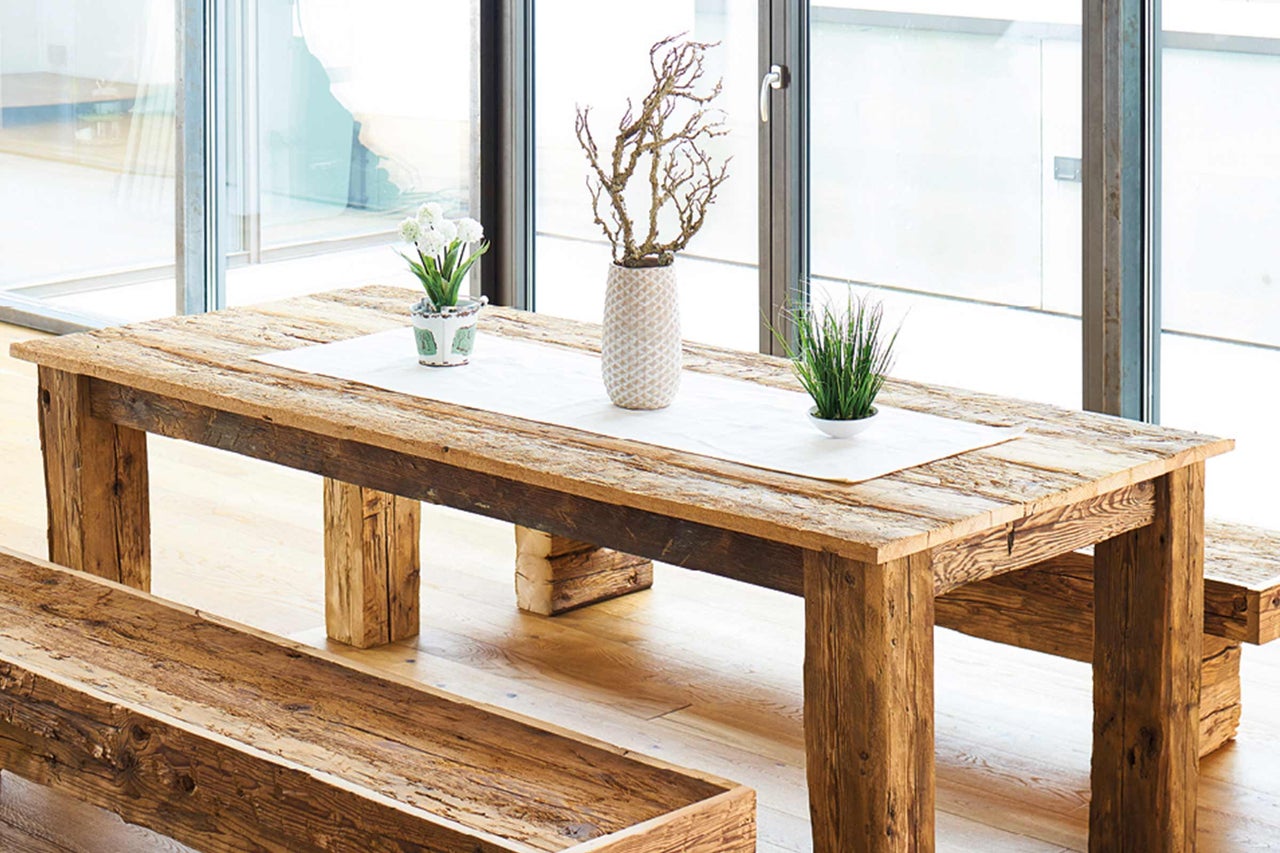 Esstischgruppe aus Holz mit Bank und Tischdekoration