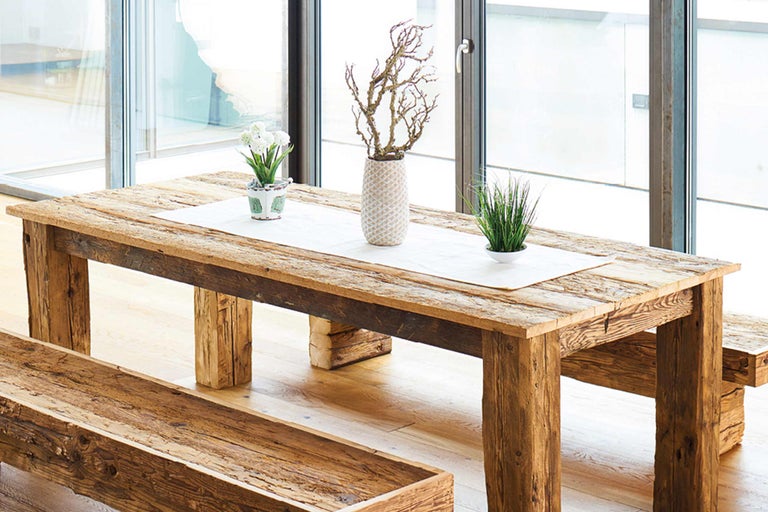Esstischgruppe aus Holz mit Bank und Tischdekoration