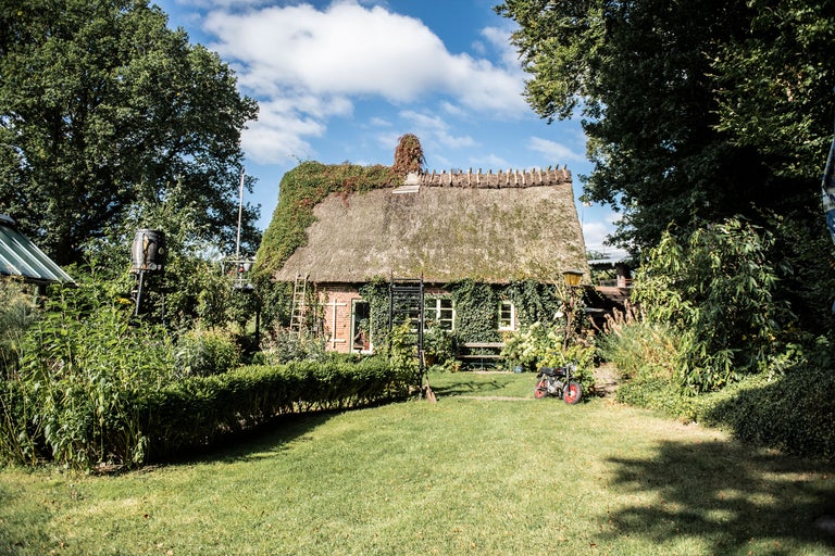 Haus mit Strohdach und Gartenanlage