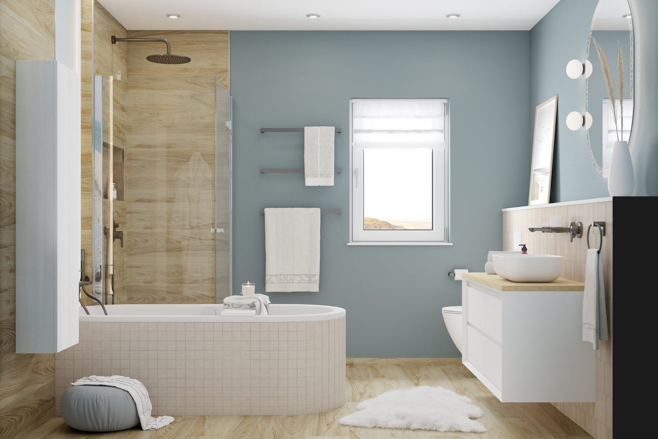 Badezimmer mit Badewanne, Waschtisch, Handtüchern und Fenster für ein helles Ambiente