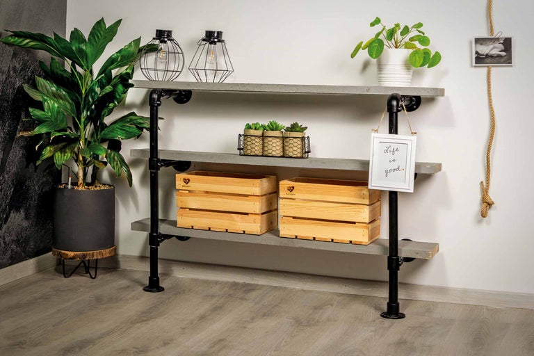 Regal mit drei Ebenen aus Holz und schwarzen Metallrohren, dekoriert mit Pflanzen, Holzboxen, Lampen und einem Rahmen