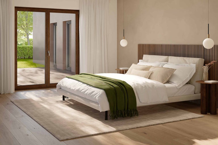 Helles Schlafzimmer mit Bett, Nachttischen, Teppich und Terrassentür