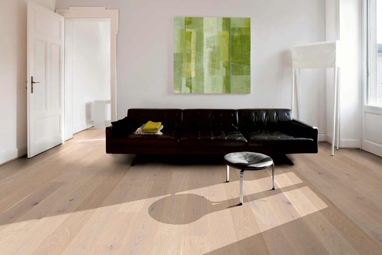 Heller Holzboden in einem Wohnzimmer mit Sofa und Kunstwerk